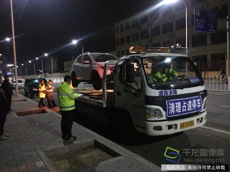 3月19日晚上7点半，北京通州交通支队出动两台道路清障车、一台叉车赶到梨园路，进行清障执法行动，引得大量群众围观和拍手叫好。图为通州区交警支队执法现场。千龙网记者 于振华摄